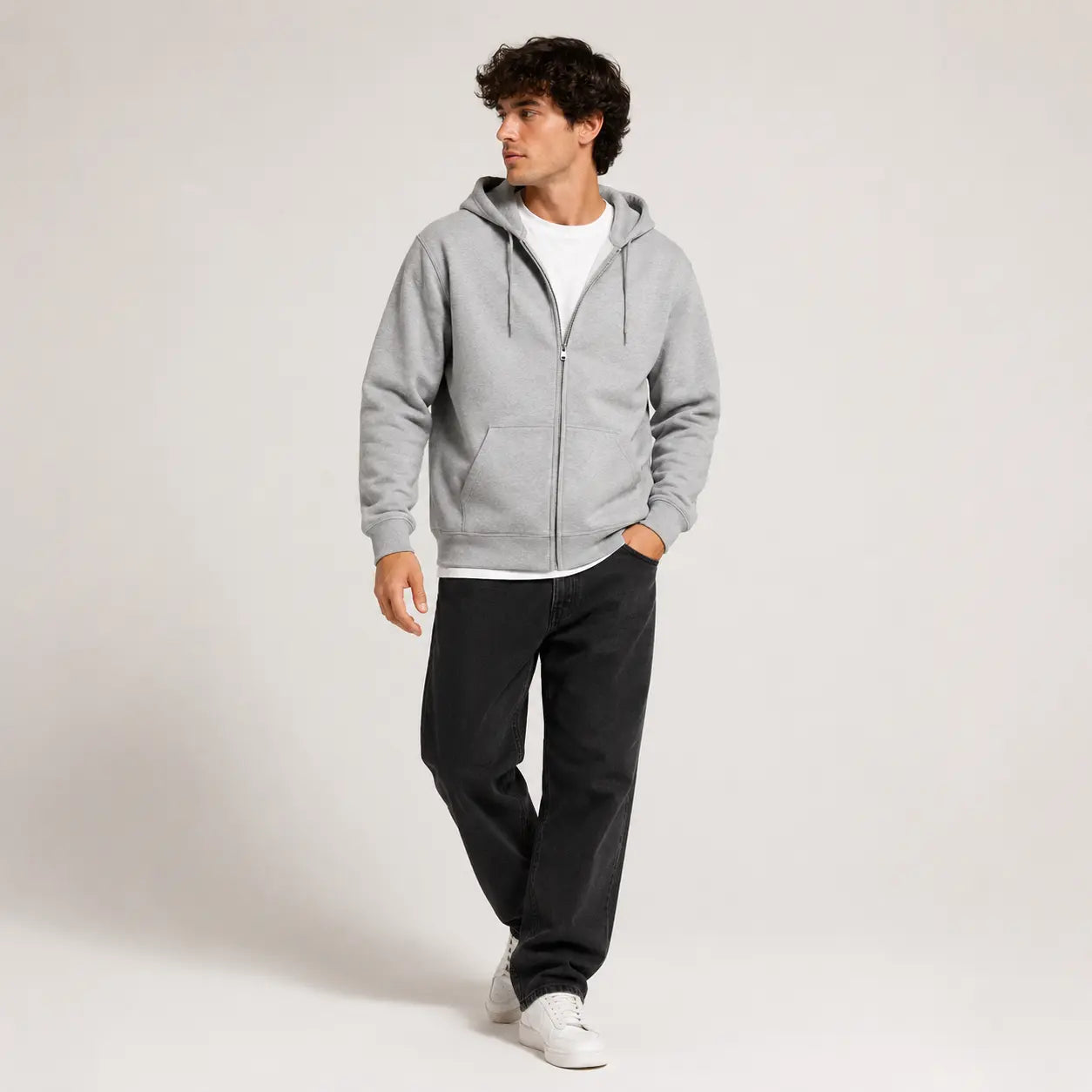 Sudadera con capucha gris, vista frontal, con cierre y cordones, combinada con camiseta blanca y pantalones oscuros.