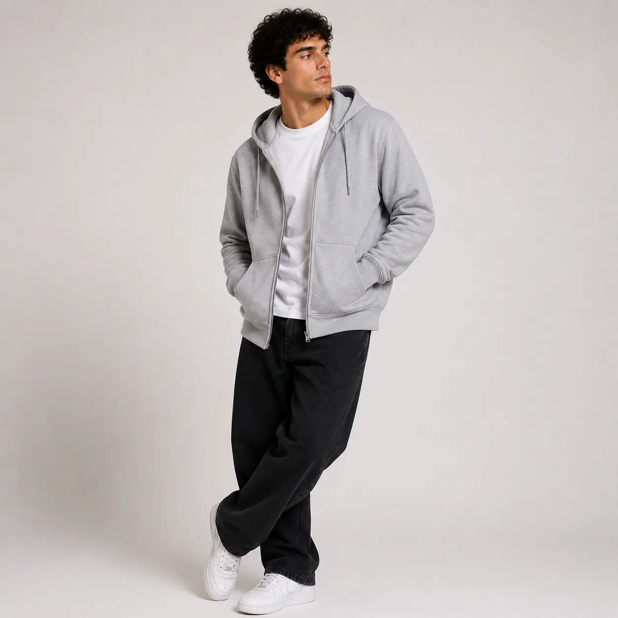 Sudadera con capucha gris, vista frontal, combinada con camiseta blanca y pantalones negros.