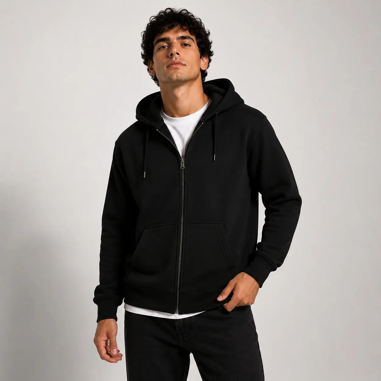 Sudadera con capucha negra, vista frontal, con cierre y cordones. Modelo masculino, prenda básica y versátil para uso diario.